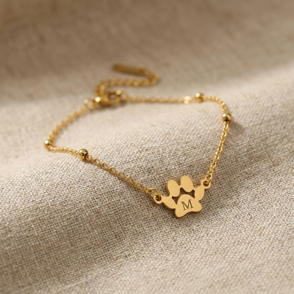 Close-up of the paw charm engraved with the letter M