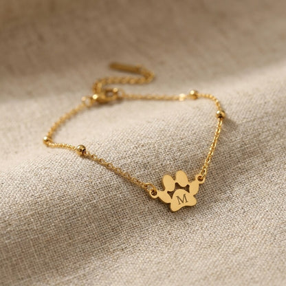 Close-up of the paw charm engraved with the letter M