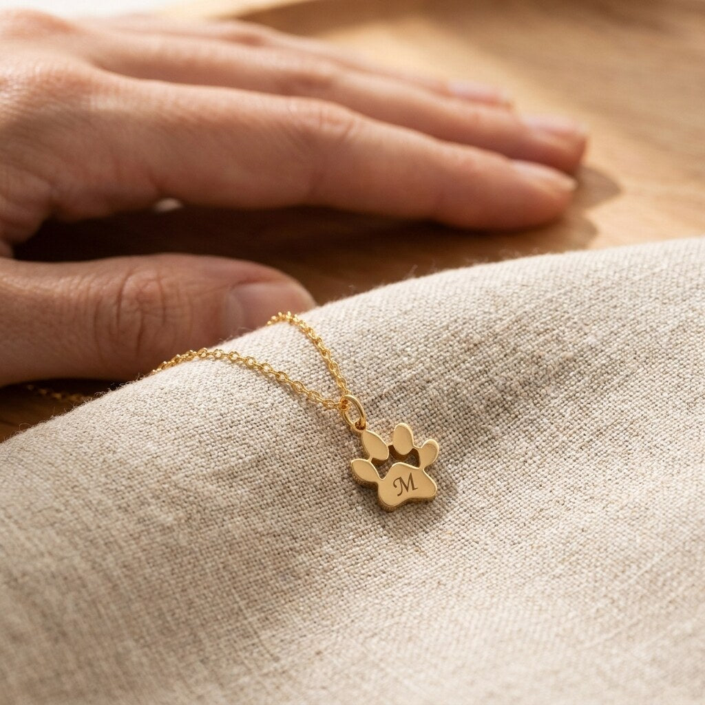 Close-up of the paw pendant engraved with the letter M