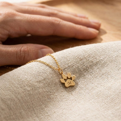 Close-up of the paw pendant engraved with the letter M